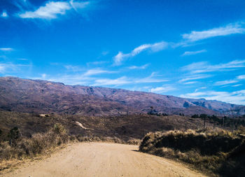 Scenic view of landscape and mountains against blue sky