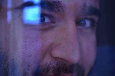 Through the glass.close-up.look of a man.brown eyes of a man.face.nose.eyebrows.