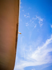 Low angle view of airplane wing against sky