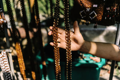 Close-up of hand holding chain hanging on playground