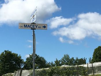 Low angle view of information sign against blue sky