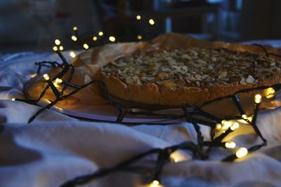 Close-up of sweet food with illuminated string light on table