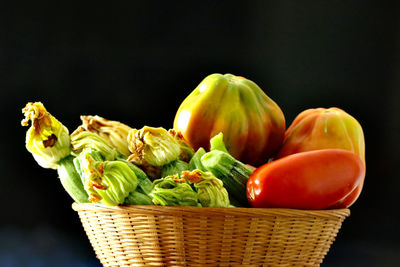 Close-up of fruits in basket against black background