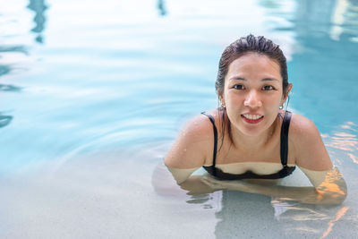 Portrait of a smiling young woman swimming in pool