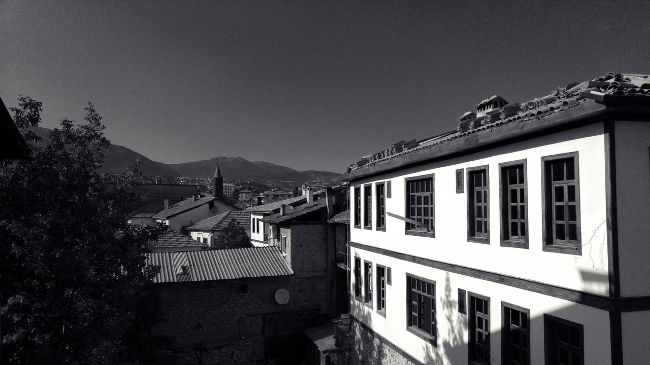 building exterior, architecture, built structure, residential structure, house, residential building, clear sky, mountain, residential district, window, copy space, town, sky, roof, city, building, day, outdoors, tree, blue