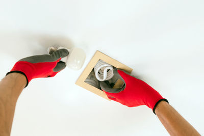 Close-up of hand holding umbrella over white background