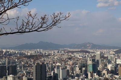 Aerial view of buildings in city against sky