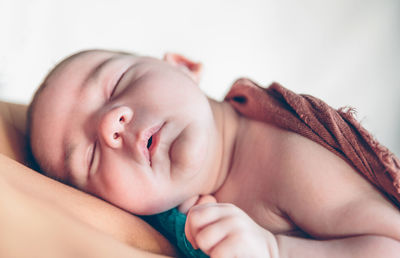 Close-up of baby sleeping on bed