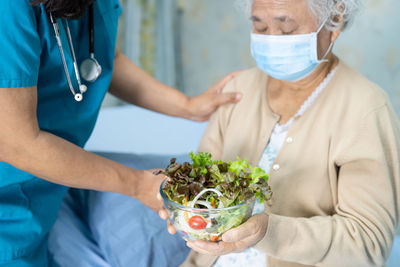 Nurse giving salad to patient in hospital