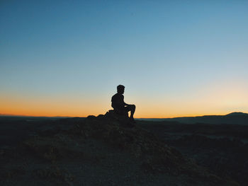 Silhouette of person looking at sunset