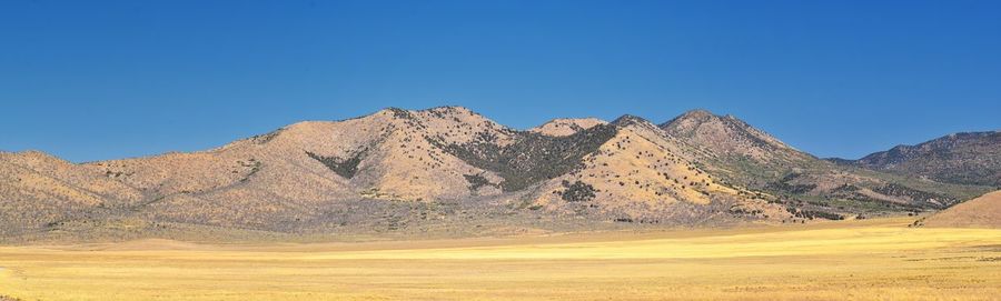 Scenic view of rocky mountains against clear blue sky
