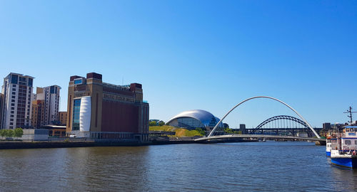 City at waterfront against blue sky