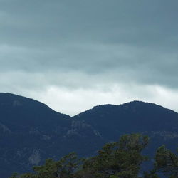 Scenic view of mountains against cloudy sky