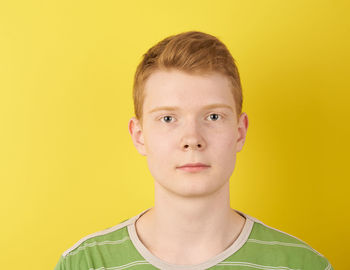 Portrait of teenage boy against yellow background