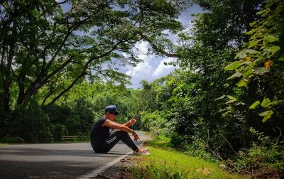 Side view of man sitting in forest