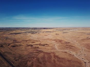 Scenic view of desert against blue sky