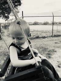 Rear view of girl sitting on land