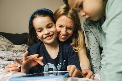 Happy woman with sons using digital tablet at home