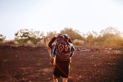 Rear view of woman standing on field