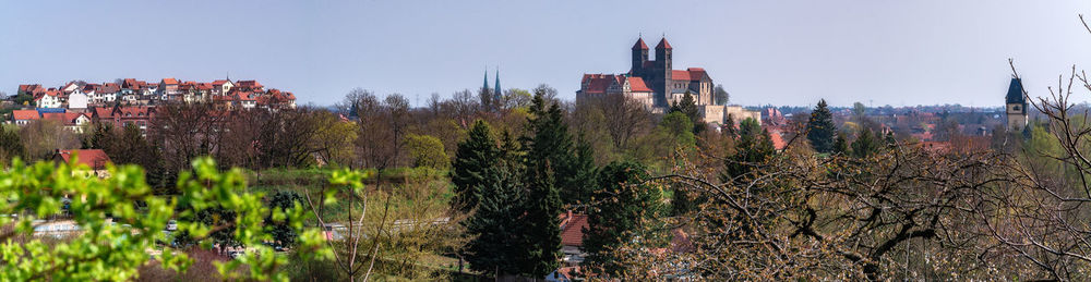 Panoramic view of trees and buildings against sky