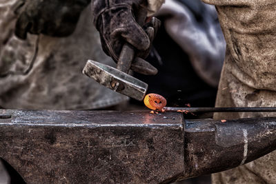 Blacksmith forging hot metal with hammer