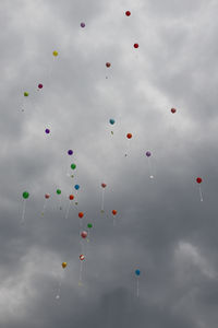 Low angle view of balloons flying against sky