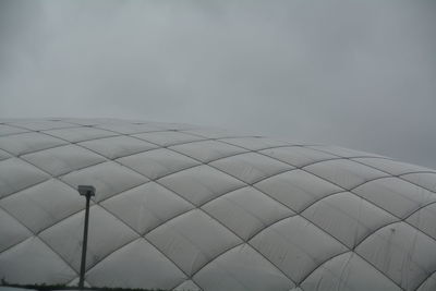 Stadium roof against cloudy sky at dusk
