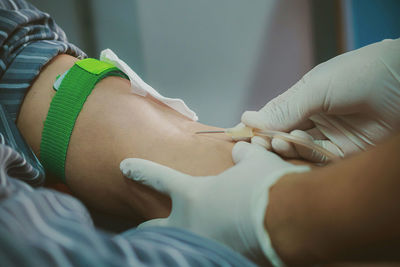 Close-up of doctor inserting iv drip in patient hand at hospital