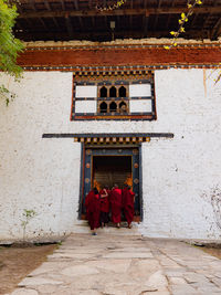 Rear view of monks entering building