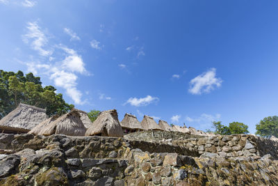 Low angle view of rocks against blue sky