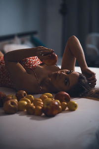 Cropped hand of woman sitting on bed at home