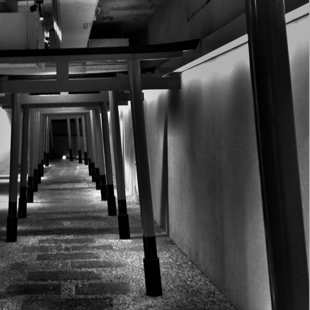 indoors, in a row, architecture, built structure, architectural column, corridor, the way forward, diminishing perspective, column, empty, flooring, colonnade, ceiling, repetition, vanishing point, sunlight, incidental people, absence, railing, day