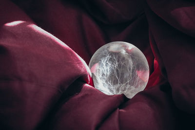 Close-up of crystal ball on red fabric