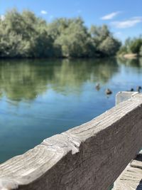 Close-up of wood by lake against sky