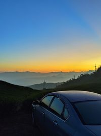 Car on road against sky during sunset