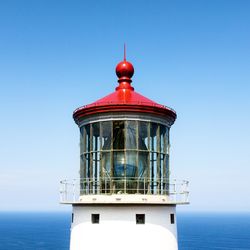 Lighthouse by sea against sky