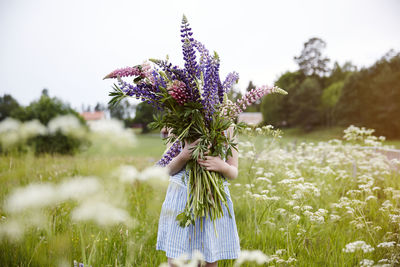 Girl holding flowers on meadow