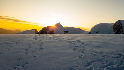 View of snow covered land during sunset