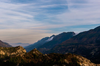 Scenic view of mountains against cloudy sky