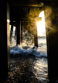 View of pier in sea during sunset