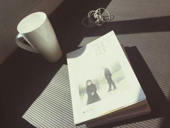 High angle view of coffee cup and book on table