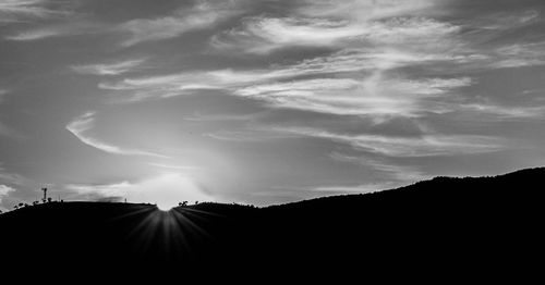 Silhouette of mountain range against cloudy sky