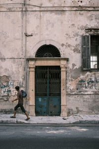 Side view of man standing by building