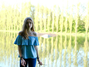 Portrait of teenage girl standing by lake