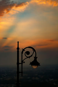 Low angle view of silhouette metal against sky during sunset