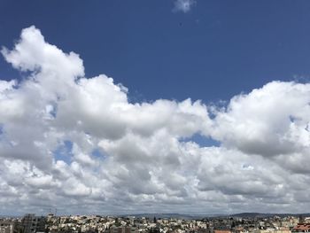 Aerial view of city against cloudy sky