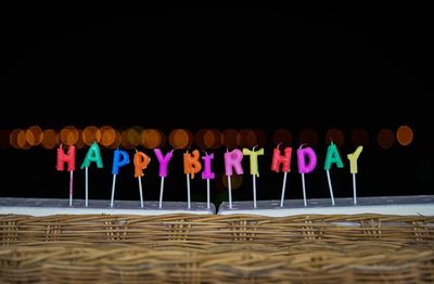 Multi colored umbrellas on glass against illuminated background