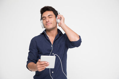 Young man using mobile phone against white background