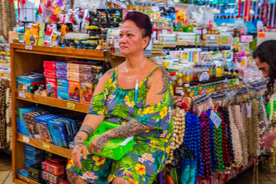 Full length of a smiling young woman standing in store