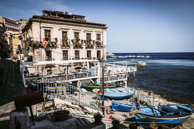 Ship moored on sea against buildings in city